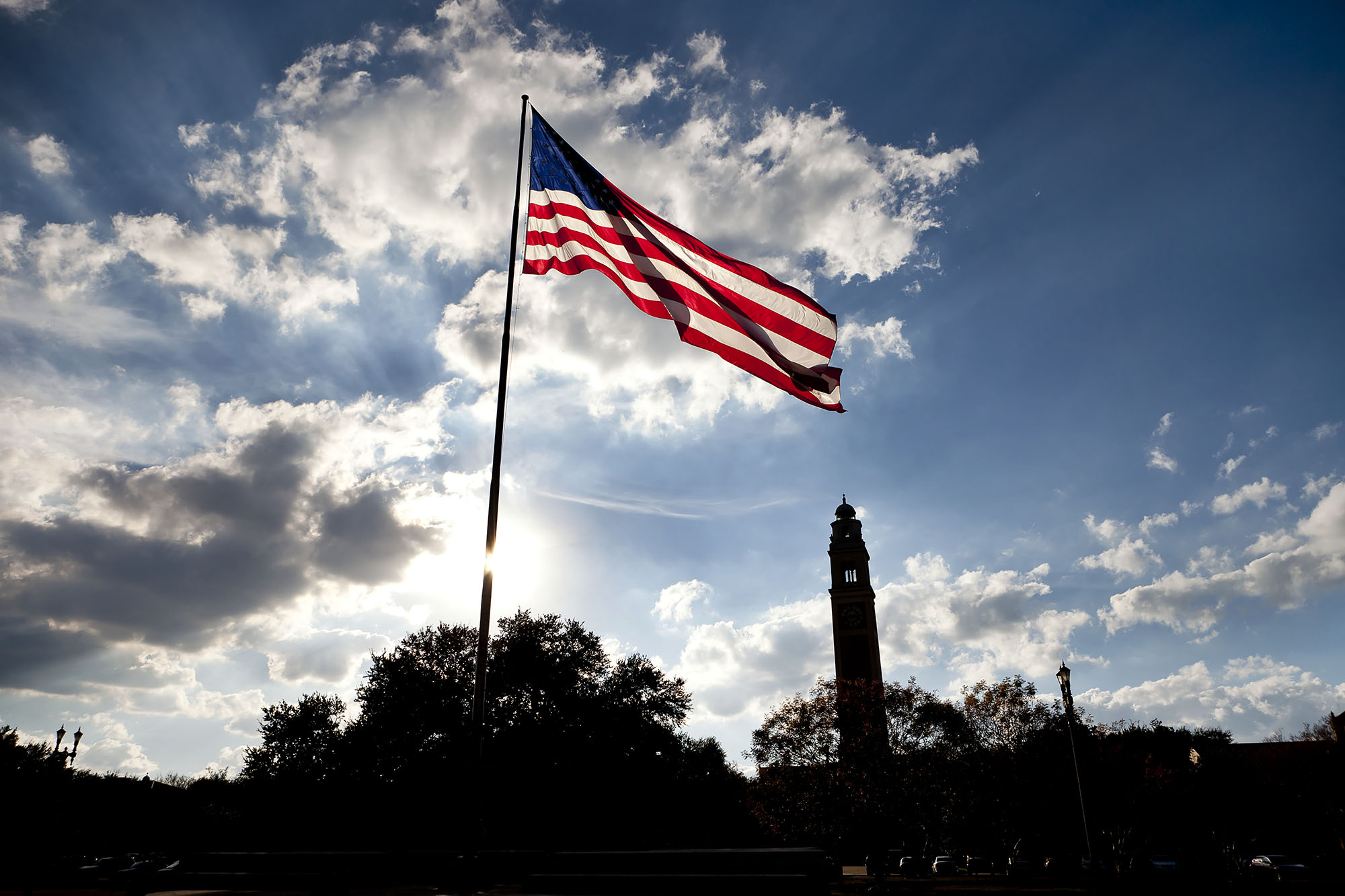 U.S. flag on LSU campus with Memorial Tower in the background