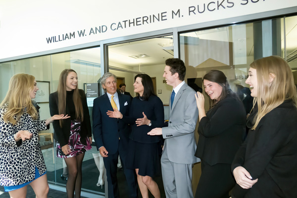 Billy and Catherine Rucks smile with students in front of department.