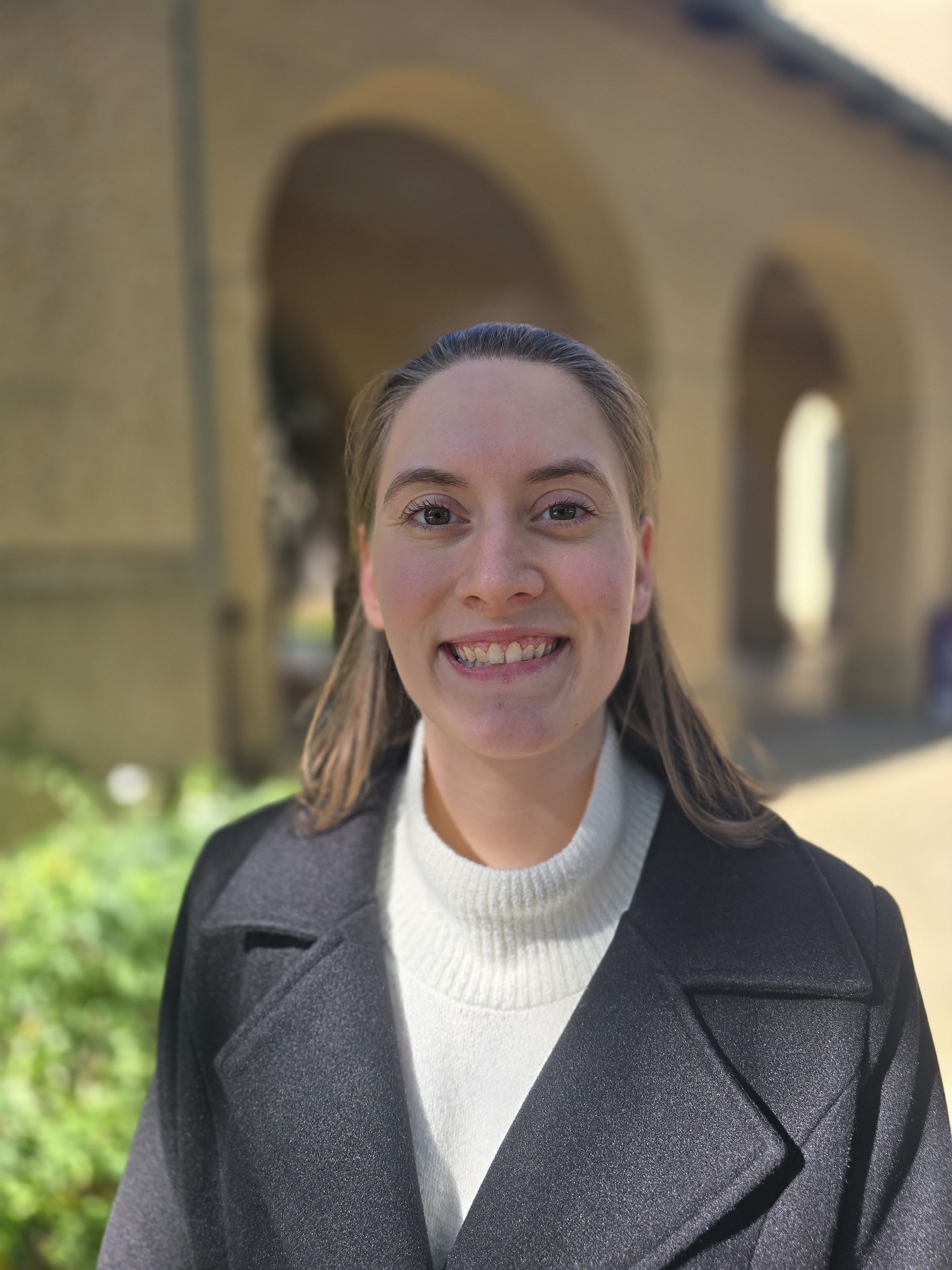 picture of study abroad advisor in quad with arches behind them