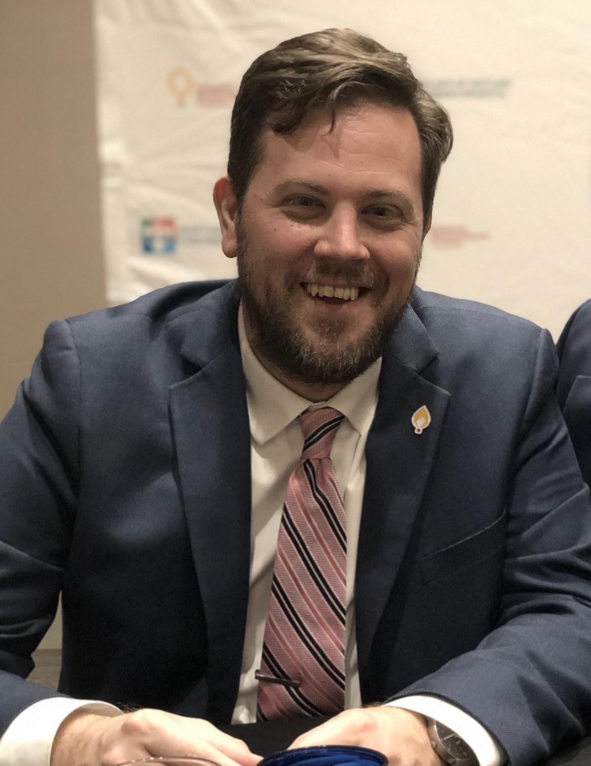 Photo of Bill Matera smiling at desk.